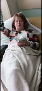 Mom resting asleep in a fold-out hospital bed during her visit to Brad.