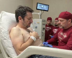 AI-generated image of doctors depicted as superheroes with Superman logos, symbolizing strength and support in the fight against NK/T-cell lymphoma, with Brad in the hospital receiving care.